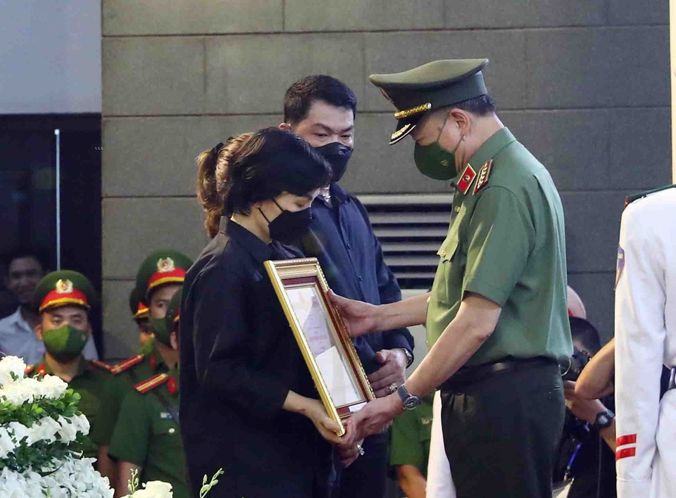 Đại tướng Tô Lâm, Ủy viên Bộ Chính trị, Bộ trưởng Bộ Công an trao Huân chương Chiến công hạng Nhất cho gia đình Hạ sỹ Nguyễn Đình Phúc (Chiến sỹ nghĩa vụ, Đội Cảnh sát phòng cháy chữa cháy và cứu nạn cứu hộ, Công an quận Cầu Giấy). (Ảnh: Phạm Kiên/TTXVN)