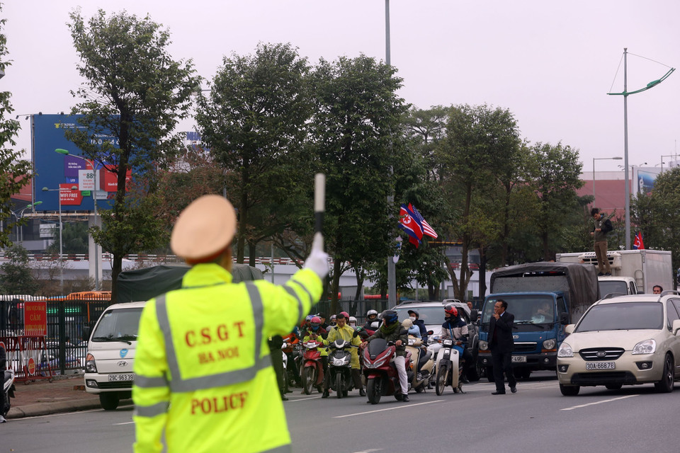 Cảnh sát giao thông ra hiệu lệnh tạm dừng các phương tiện lưu thông để nhường đường cho các đoàn xe của đoàn Mỹ tới Việt Nam. (Ảnh: Huy Hùng/TTXVN)
