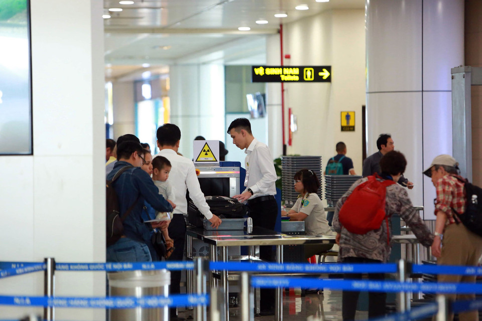 Công tác kiểm tra soi chiếu hành khách, hành lý xách tay được tăng cường. 100% hành khách phải tháo giầy, áo khoác đưa qua máy soi tia X… (Ảnh: Huy Hùng/TTXVN)