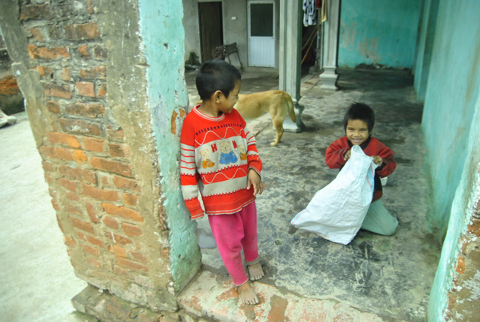 Bé Tư (7 tuổi, áo đỏ) và bé Năm (5 tuổi, áo đen) thường cả ngày chỉ quấn lấy nhau. Tuy đôi lúc nghịch phá, nhưng vẫn nghe lời bà.