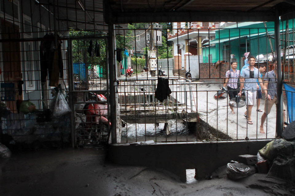 Bùn thải đã tràn vào nhà người dân. (Ảnh: Minh Quyết/TTXVN)