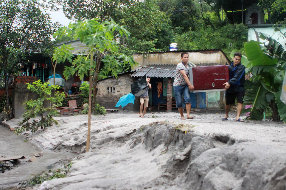 Người dân chuyển tài sản có giá trị ra khỏi nhà. (Ảnh: Minh Quyết/TTXVN)