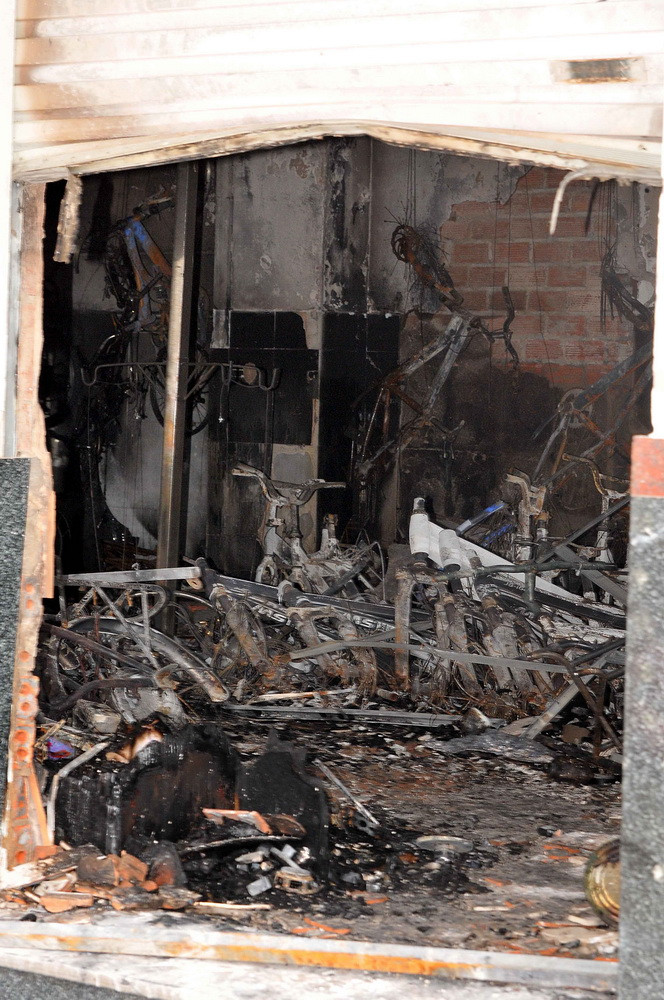 Sau gần 1 giờ, ngọn lửa được khống chế và dập tắt hoàn toàn nhưng hàng trăm xe đạp hiệu Martin và xe đạp điện của cửa hàng Dung Chinh đã bị thiêu rụi, nhiều thiết bị, lốp, ruột xe bị cháy đen. (Ảnh: An Hiếu/TTXVN)