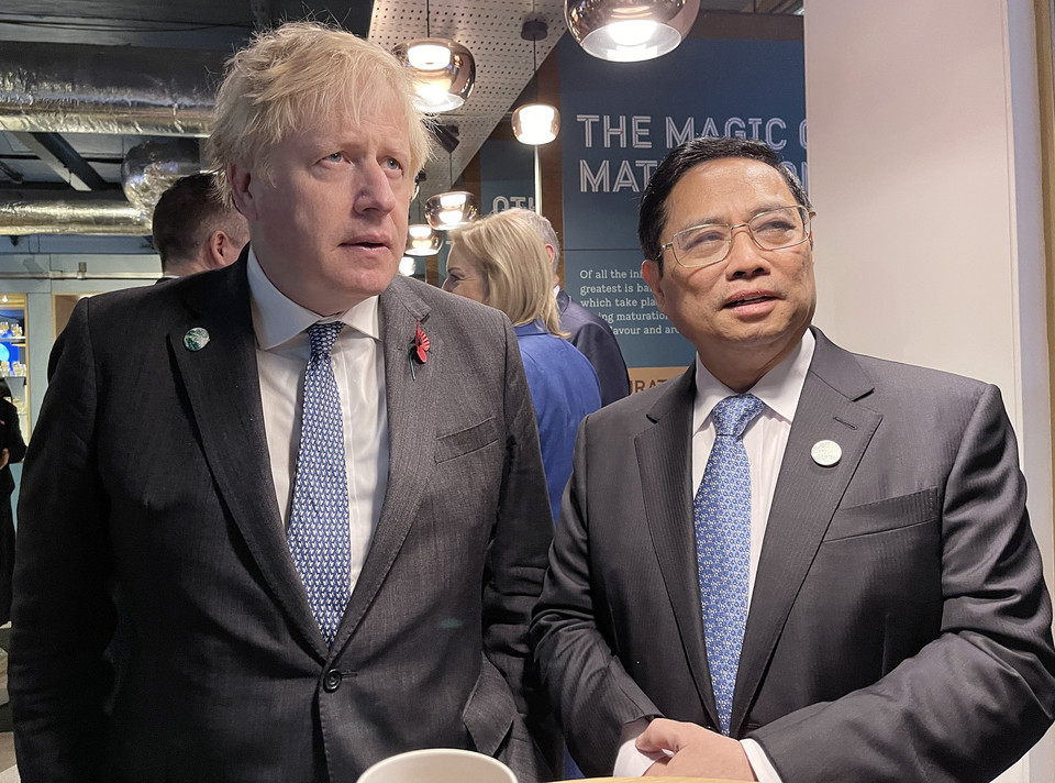 Thủ tướng Phạm Minh Chính trao đổi với Thủ tướng Vương Quốc Anh Boris Johnson. (Ảnh: TTXVN)