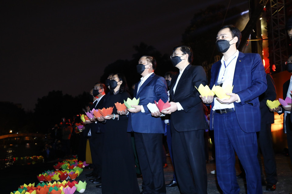 Ủy viên Bộ Chính trị, Bí thư Thành ủy Thành phố Hà Nội Đinh Tiến Dũng và Bí thư Trung ương Đảng, Trưởng Ban Dân vận Trung ương Bùi Thị Minh Hoài thả hoa đăng tưởng niệm đồng bào và cán bộ, chiến sỹ hy sinh, tử vong trong đại dịch COVID-19. (Ảnh: Minh Đức/TTXVN)