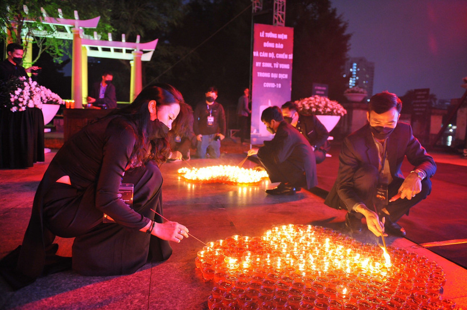 Tại Công viên Thống Nhất (Hà Nội), các đại biểu và nhân dân thắp nến tưởng niệm đồng bào và cán bộ, chiến sỹ hy sinh, tử vong trong đại dịch COVID-19. (Ảnh: Minh Đức/TTXVN)