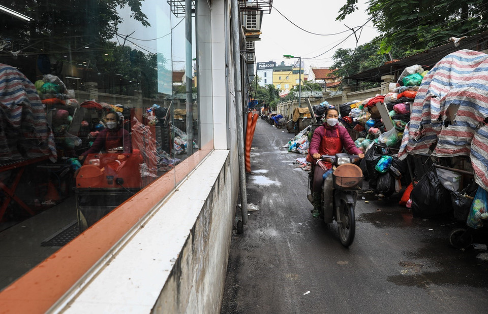 Tại đường Dương Quảng Hàm rác thải sinh hoạt bị ùn ứ, chất đống, nhiều xe rác để dưới lòng đường gây khó khăn cho người tham gia giao thông và làm mất mỹ quan đô thị. (Ảnh: Thành Đạt/TTXVN)