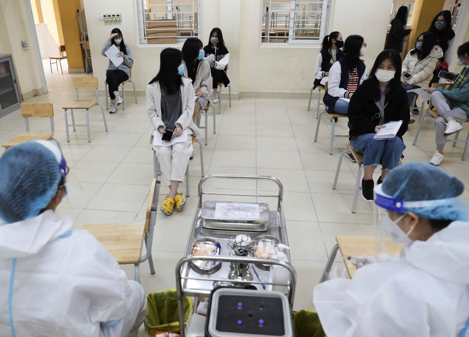 Học sinh trường THPT Trần Nhân Tông, quận Hai Bà Trưng trước giờ tiêm tại trường. (Ảnh: Thanh Tùng/TTXVN)