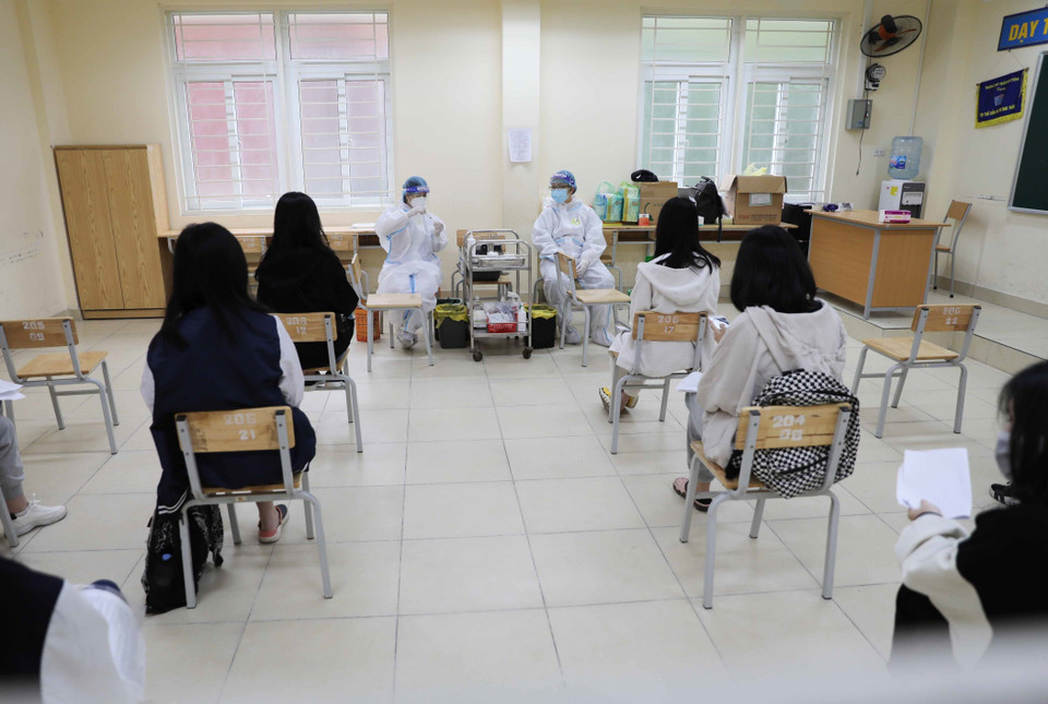 Học sinh trường THPT Trần Nhân Tông, quận Hai Bà Trưng trước giờ tiêm tại trường. (Ảnh: Thanh Tùng/TTXVN)