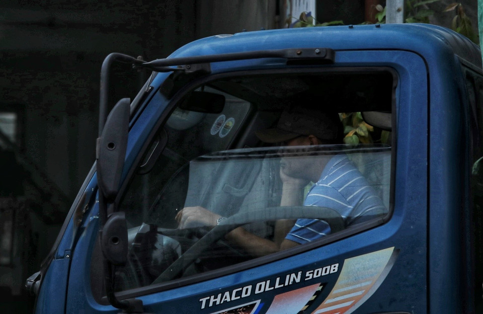 Một lái xe ngồi chờ trong cabin đến lượt đăng kiểm. (Ảnh: Tuấn Anh/TTXVN)