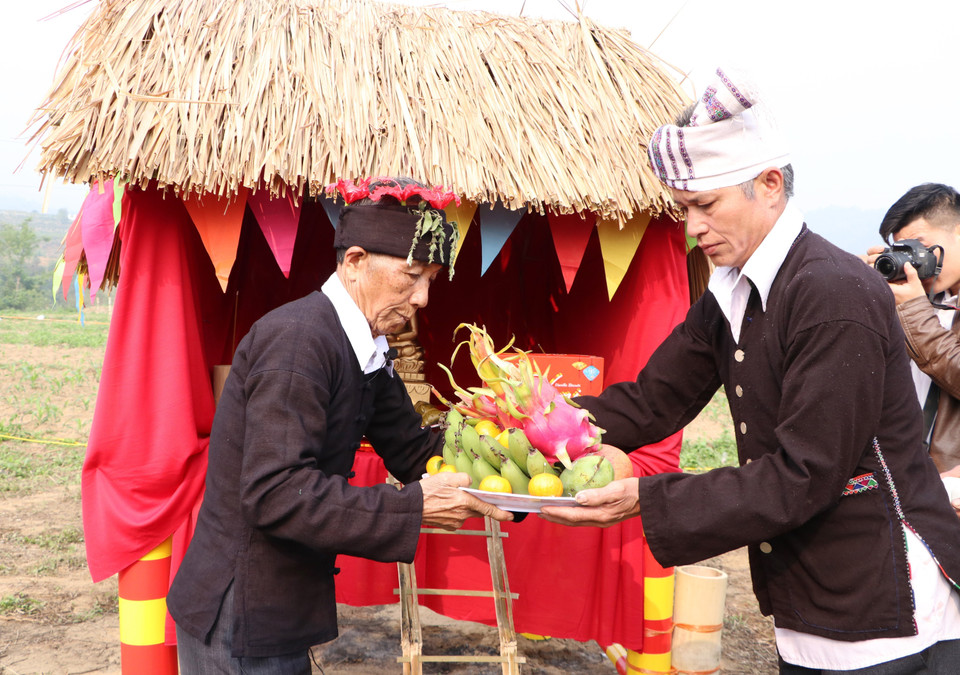 Sau khi dâng hương, thầy cúng sẽ nhận lễ vật từ tay của các già làng để dâng vào chùa. (Ảnh: Đinh Thùy/TTXVN)