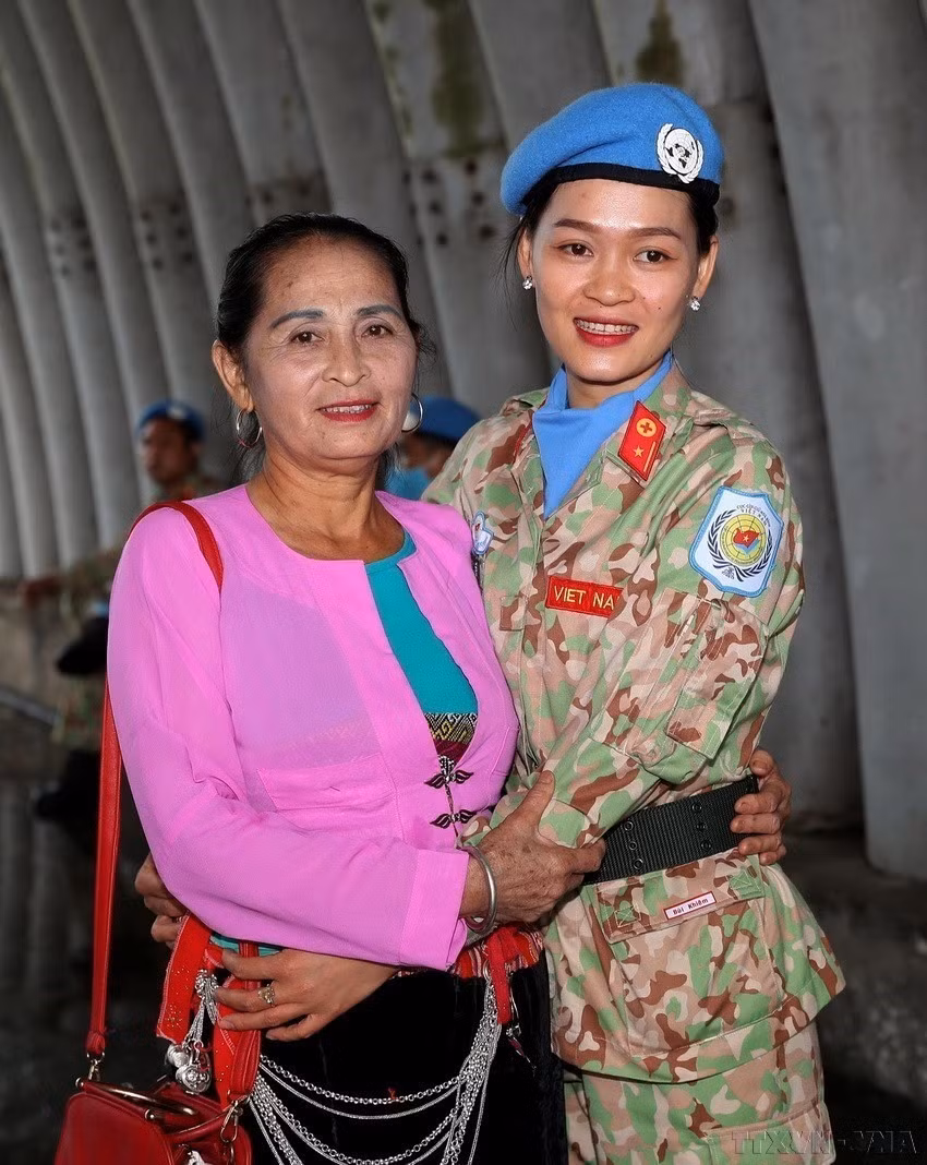 Phụ nữ tham gia vào nhiều ngành nghề, lĩnh vực, kể cả những công việc nặng nhọc, vất vả thường chỉ dành cho phái mạnh và ngày càng khẳng định vị trí, vai trò của mình. Trong ảnh: Người mẹ dân tộc Mường (Hòa Bình) tiễn con gái lên đường thực hiện nhiệm vụ gìn giữ hòa bình Liên hợp quốc. (Ảnh: Trọng Đức/TTXVN)