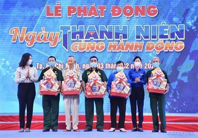 Tặng quà Tết cho cho các Đảng viên lão thành cách mạng tại lễ phát động “Ngày thanh niên cùng hành động” với chủ đề “Tuổi trẻ Việt Nam tự hào tiến bước dưới cờ Đảng.” (Ảnh: Hồng Giang/TTXVN)