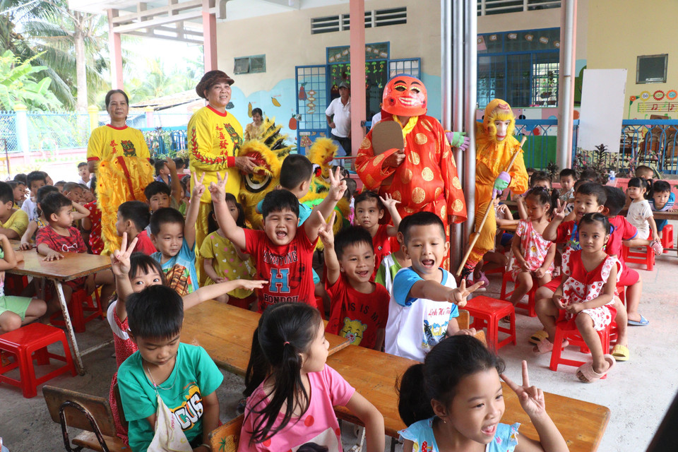 Đội lân nữ, ấp Quới Hiệp, xã Trung Thành Tây, huyện Vũng Liêm, tỉnh Vĩnh Long giao lưu với các trẻ em ở trường mầm non trên địa bàn. (Ảnh: Lê Thúy Hằng/TTXVN)