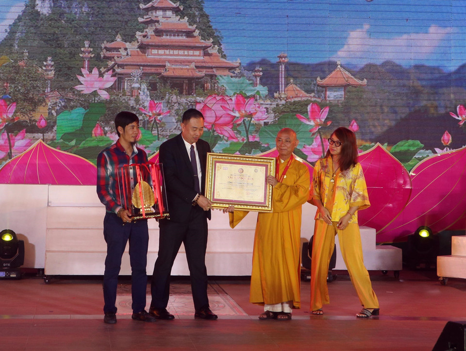 Ban Tổ chức trao chứng nhận kỷ lục Việt Nam cho độc bản Lá Bồ Đề lớn nhất được mạ vàng 24k tại Lễ hội Quán Thế Âm Ngũ Hành Sơn. (Ảnh: Trần Lê Lâm/TTXVN)