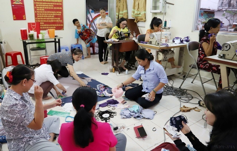 Chị em phụ nữ thuộc Hội Liên hiệp Phụ nữ phường 1, quận 4 (Thành phồ Hồ Chí Minh) may khẩu trang tặng người nghèo. (Ảnh: Đinh Hằng/TTXVN)