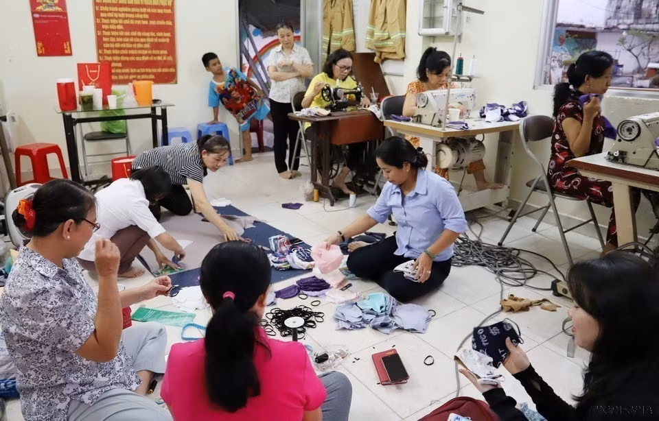 Chị em phụ nữ thuộc Hội Liên hiệp Phụ nữ phường 1, quận 4 (Thành phồ Hồ Chí Minh) may khẩu trang tặng người nghèo. (Ảnh: Đinh Hằng/TTXVN)