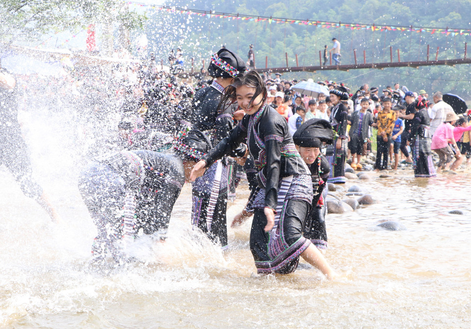 Trai bản trên, gái bản dưới, không phân biệt người già, trẻ nhỏ kéo nhau ra suối thực hiện phong tục té nước. Với quan niệm ướt càng nhiều, may mắn sẽ đến càng nhiều nên ai cũng mong mình được té ướt càng nhiều càng tốt. (Ảnh: Đinh Thùy/TTXVN)