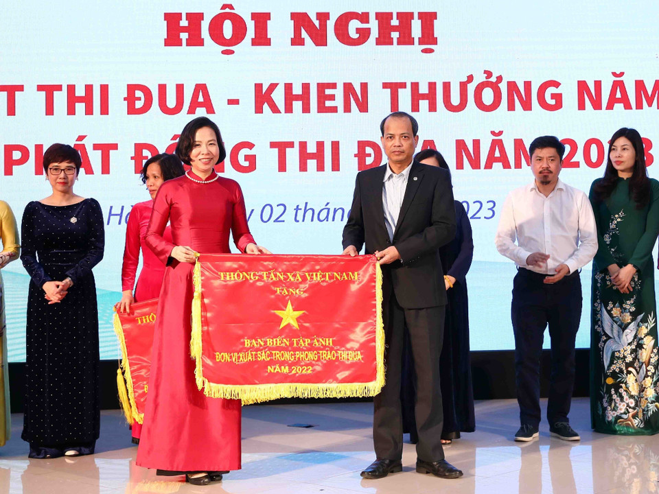 Tổng Giám đốc Thông tấn xã Việt Nam Vũ Việt Trang trao cờ thi đua của Thông tấn xã Việt Nam cho tập thể Ban Biên tập Ảnh. (Ảnh: Phạm Kiên/TTXVN)