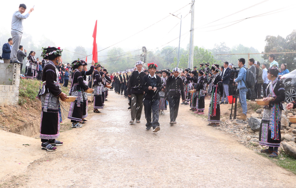 Các gia đình trong bản đứng hai bên đường để té nước vào đoàn rước nước dâng lên cúng tượng Phật với mong muốn cho gia đình năm mới sẽ được may mắn, sức khỏe, làm ăn phát đạt. (Ảnh: Đinh Thùy/TTXVN)