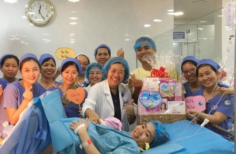 Trong giáo dục, đào tạo và y tế, cán bộ nữ chiếm tỷ lệ lớn, nhiều người có trình độ cao. Trong ảnh: Ban giám đốc, êkíp trực đêm tại Bệnh viện Từ Dũ tặng quà cho sản phụ sinh con đầu tiên trong năm 2020. (Ảnh: Đinh Hằng/TTXVN)