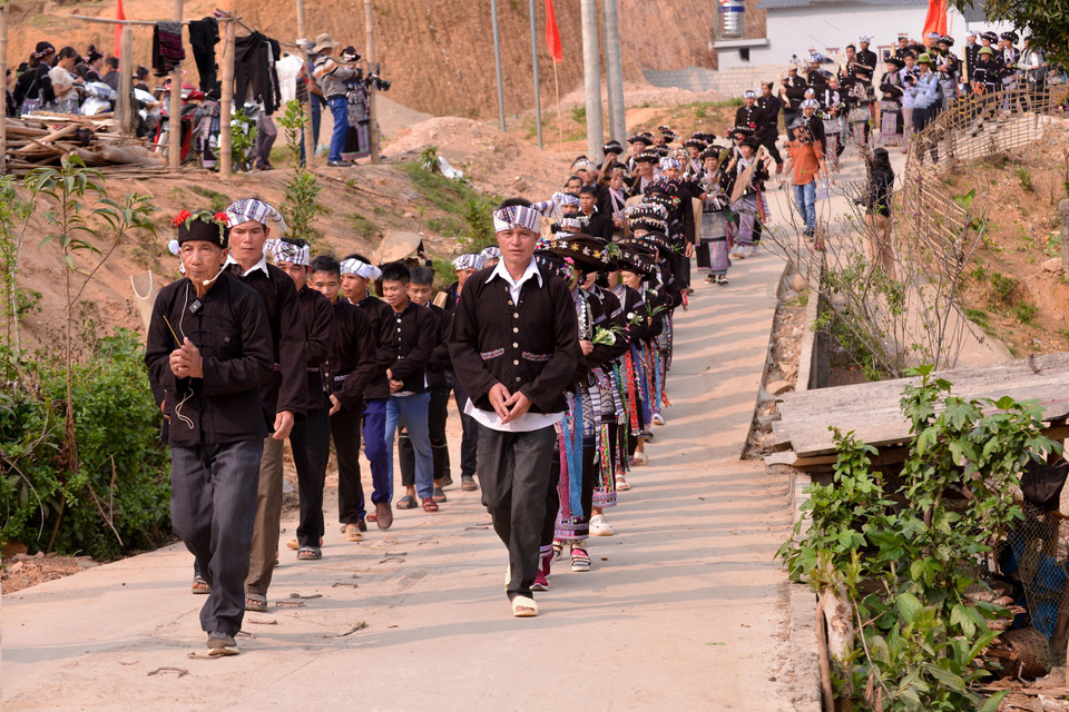 Thầy cúng và đoàn rước đi tới các gia đình được chọn để xin nước mưa. (Ảnh: Đinh Thùy/TTXVN)