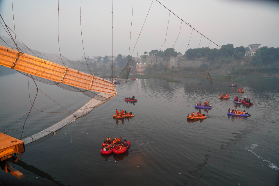 Ngày 30/10/2022, dây cáp của cầu treo qua sông Machchu thuộc thị trấn Morbi, bang Gujarat, miền Tây Ấn Độ, bị đứt khi gần 500 người, trong đó có phụ nữ và trẻ em, đang có mặt ở khu vực cầu để hành lễ trong dịp Lễ hội tôn giáo Diwali, khiến một phần cấu trúc cầu gãy, làm nhiều người rơi xuống sông Machchu bên dưới. Ít nhất 137 người đã thiệt mạng trong vụ việc. Trong ảnh: Nhân viên cứu hộ tìm kiếm người mất tích trong vụ sập cầu. (Ảnh: THX/TTXVN)
