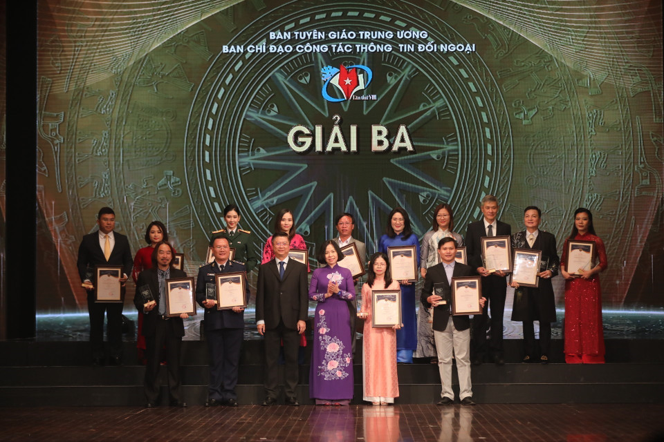 Ông Trương Quang Hoài Nam, Phó trưởng Ban Đối ngoại Trung ương và bà Vũ Việt Trang, Tổng giám đốc TTXVN trao giải Ba cho các tác giả, nhóm tác giả đoạt giải. Ảnh: Minh Quyết - TTXVN