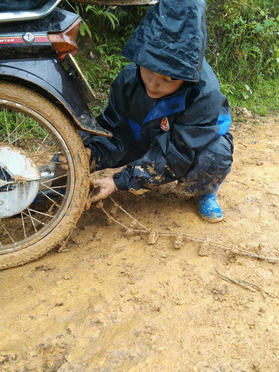 Vào ngày mưa, để đến được điểm trường Nong Phụ (Trường mầm non Hoa Phong Lan), các cô giáo phải lắp thêm dây xích tự chế vào bánh xe để đỡ trơn trượt. (Ảnh: Hữu Quyết/TTXVN)