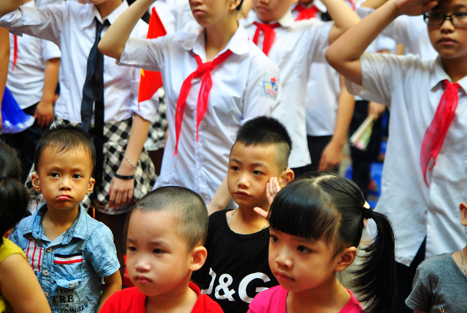 Có lẽ chào cờ sẽ là bài học đầu tiên của cậu bé này!. (Ảnh: Võ Phương/Vietnam+)