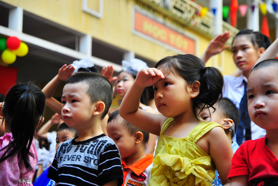 Dù hơi mướt mải, nhưng vẫn chào cờ rất ngoan. (Ảnh: Võ Phương/Vietnam+)