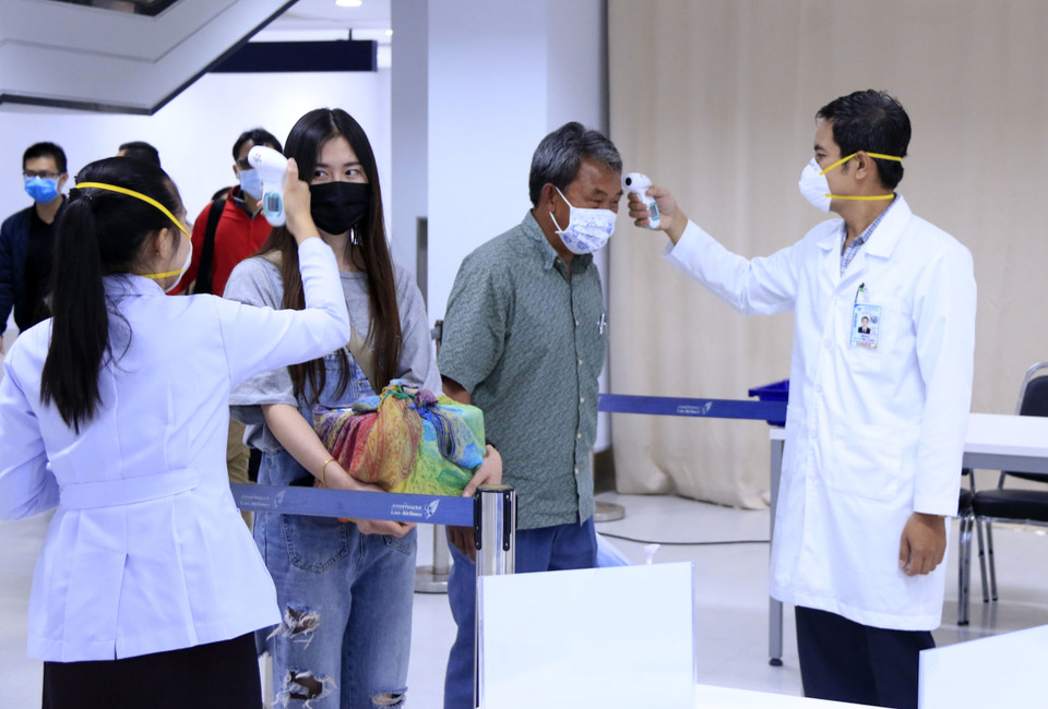 Hành khách đi trong nội địa cũng bị kiểm tra thân nhiệt chặt chẽ, sau đó sẽ được yêu cầu sát khuẩn tay trước khi vào khu an ninh. (Ảnh: Phạm Kiên/Vietnam+)