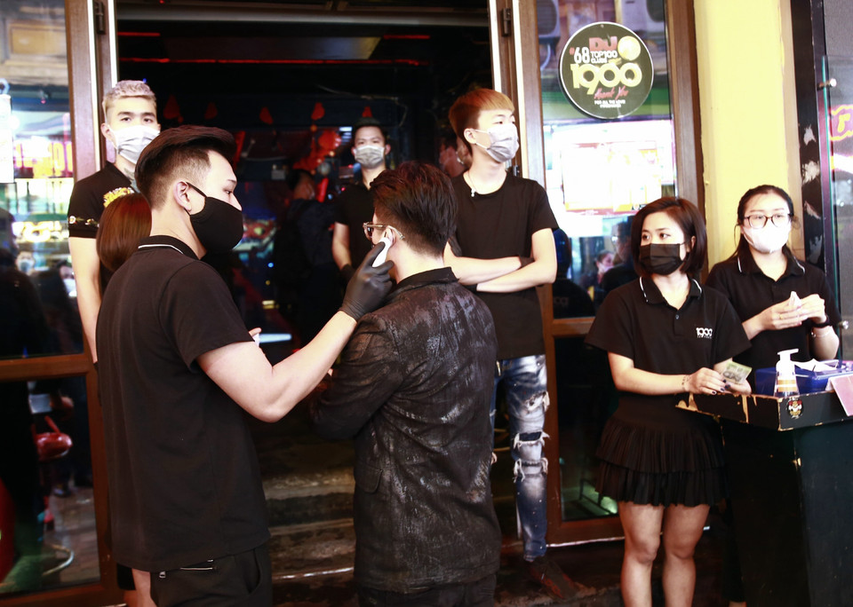 Khách hàng vào các quán bar, karaoke phải đo thân nhiệt. (Ảnh: Doãn Tấn/TTXVN)
