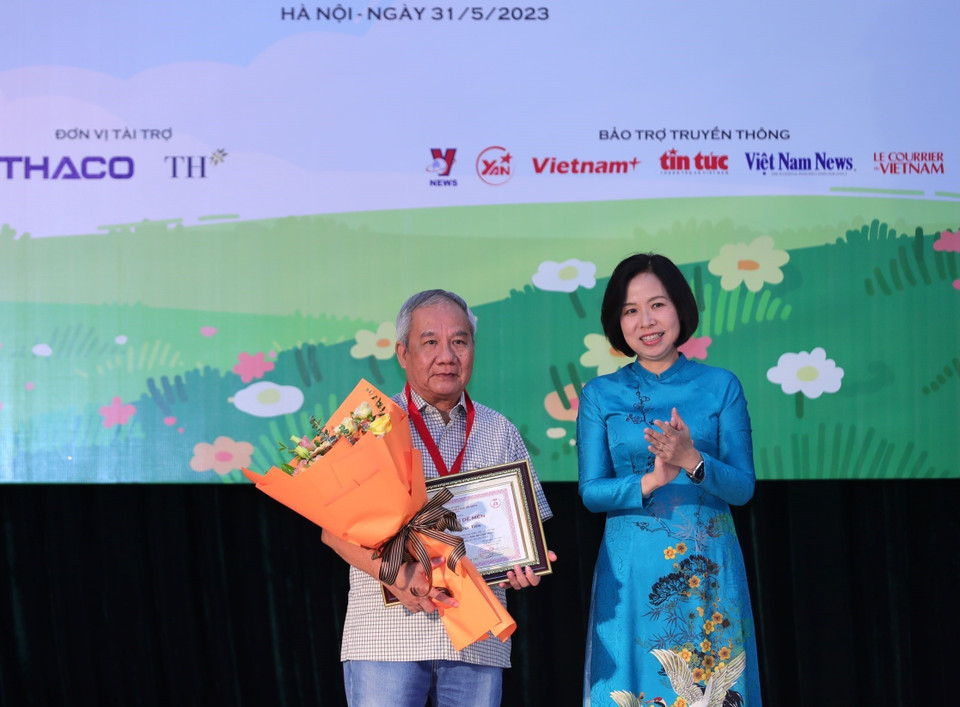 Tổng Giám đốc TTXVN Vũ Việt Trang trao Giải thưởng lớn “Hiệp sỹ Dế mèn” và chứng nhận cho nhà văn Trần Đức Tiến với truyện dài “A lô! Cậu đấy à.” (Ảnh: Hoàng Hiếu/TTXVN)