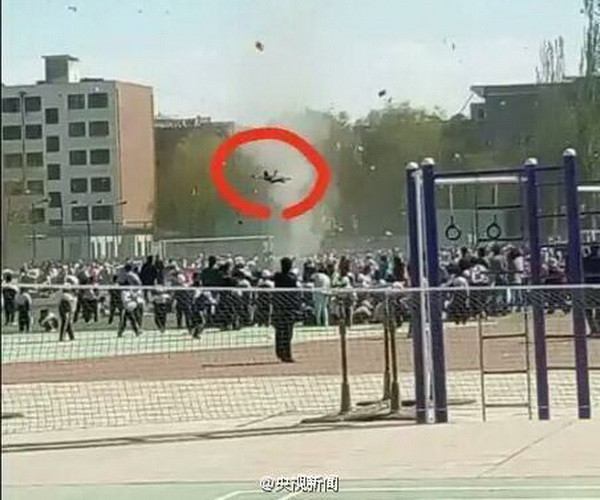 Lý Giai Kỳ, học sinh lớp 3 một trường tiểu học ở Trung Quốc, bỗng bay bổng lên không trung sau khi một cơn bão cát quét qua sân vận động huyện Qua Châu, tỉnh Cam Túc, Trung Quốc. (Nguồn: CCTV)