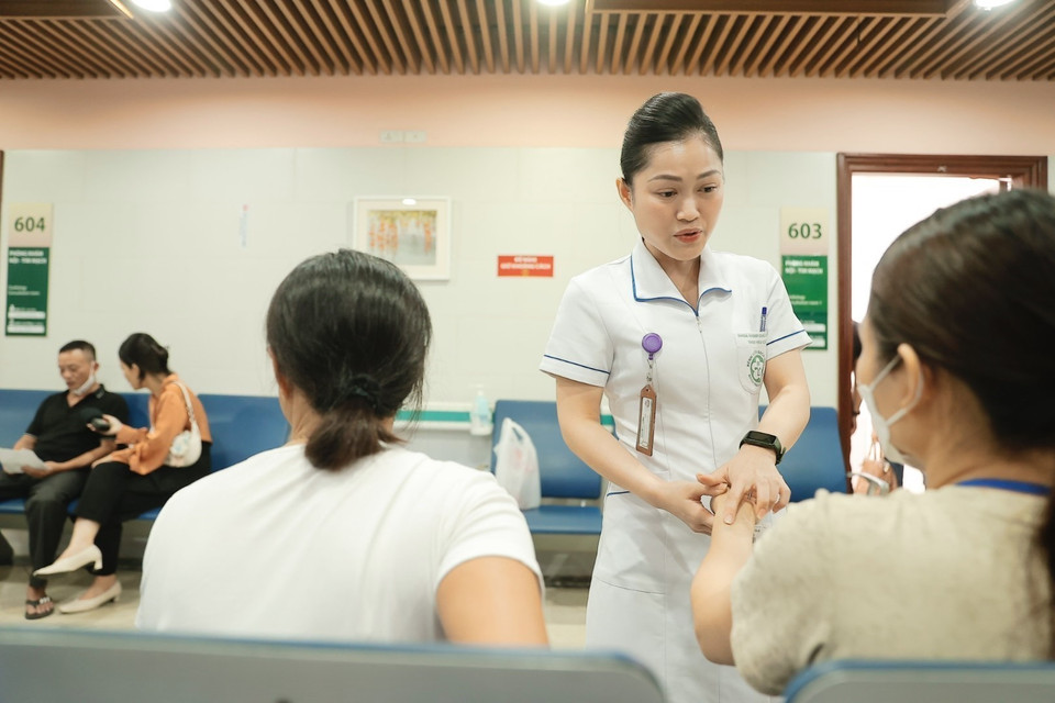 Nhân viên y tế hỗ trợ bệnh nhân đến khám bệnh. (Ảnh: Minh Quyết/TTXVN)