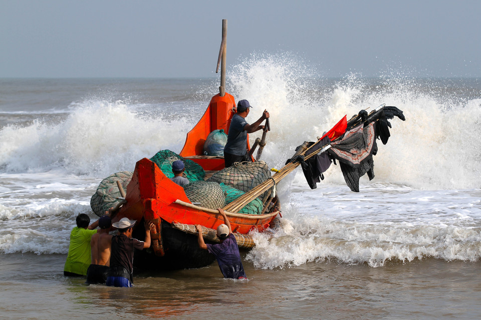 Thuyền của ngư dân vượt sóng dữ ra khơi. (Ảnh: Hồ Cầu/ TTXVN)