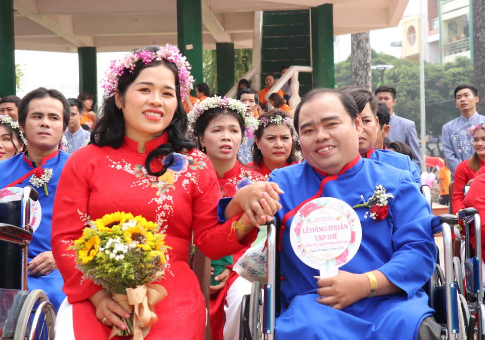 Nụ cười hạnh phúc của những cặp vợ chồng khuyết tật trong ngày cưới. (Ảnh: Xuân Khu/TTXVN)
