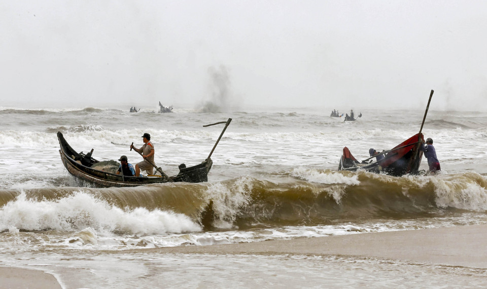 Những đoàn thuyền của ngư dân vượt sóng dữ ra khơi. (Ảnh: Hồ Cầu/TTXVN)