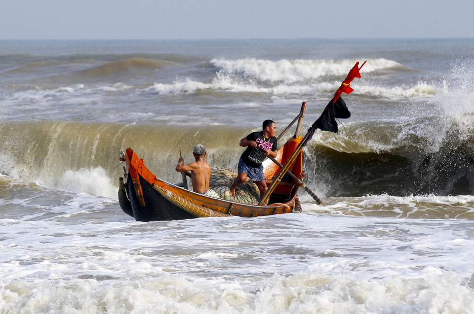 Thuyền của ngư dân vượt sóng dữ ra khơi. (Ảnh: Hồ Cầu/TTXVN)