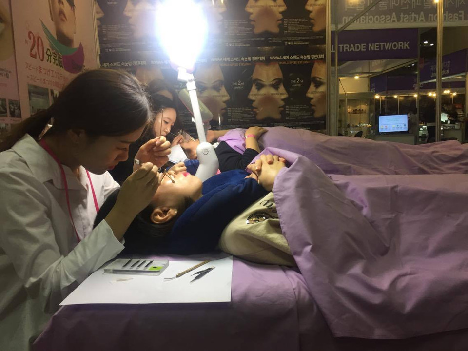 Khách hàng trải nghiệm dịch vụ nối mi. (Ảnh: Lan Phương/Vietnam+)