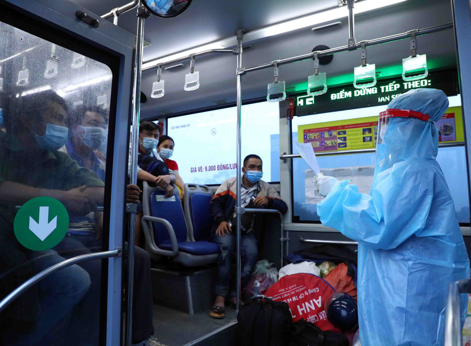 Lực lượng y tế kiểm tra khai báo của người dân có nhu cầu nguyện vọng về địa phương. (Ảnh: Phạm Kiên/TTXVN)