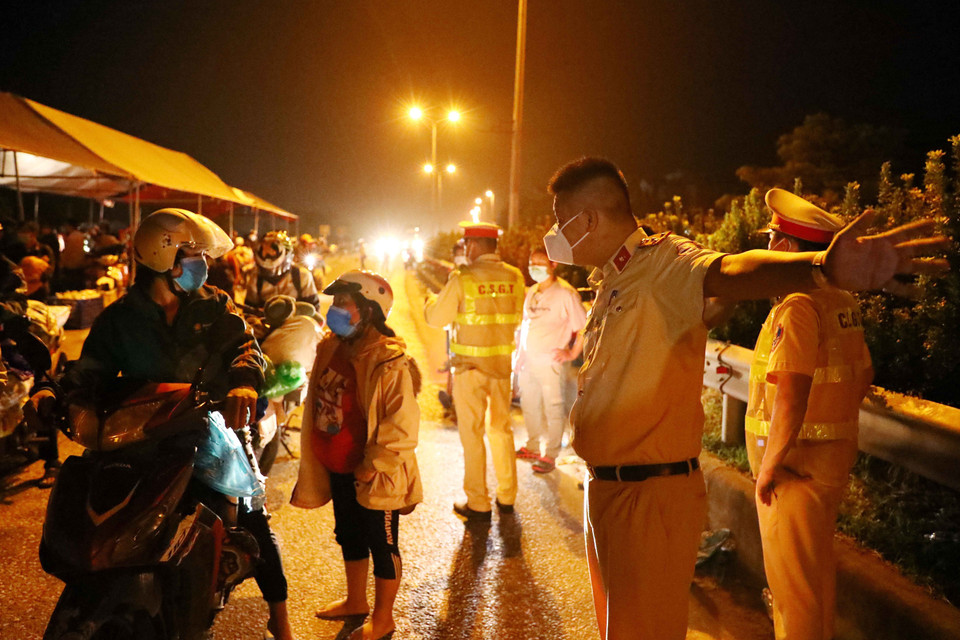 Lực lượng cảnh sát giao thông hướng dẫn đường đi cho người dân đi từ vùng dịch phía Nam về quê qua địa bàn Hà Nội. (Ảnh: Phạm Kiên/TTXVN)