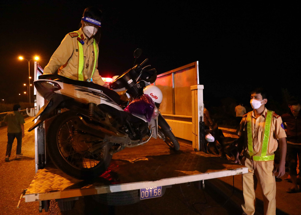 Lực lượng cảnh sát giao thông giúp đỡ người dân vận chuyển xe máy về đến điểm tập kết tại điểm cầu Trung Hà về các tỉnh Tây Bắc và theo hướng quốc lộ 1A về các tỉnh phía Bắc và Đông Bắc. (Ảnh: Phạm Kiên/TTXVN)