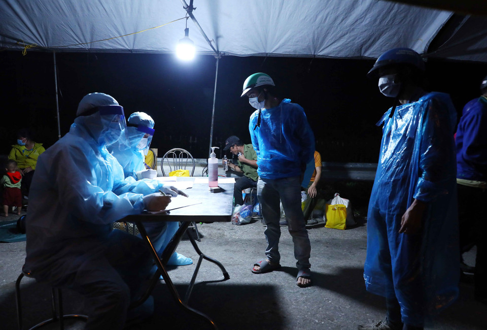 Người dân đi từ vùng dịch phía Nam về quê qua địa bàn Hà Nội sẽ được lực lượng chức năng tại chốt kiểm dịch số 1, QL 1A, huyện Phú Xuyên phân loại theo nguyện vọng về địa phương. (Ảnh: Phạm Kiên/TTXVN)