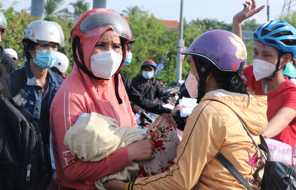 Trong số hàng nghìn người đổ về quê có nhiều trẻ sơ sinh được bố mẹ đưa đi cùng. (Ảnh: Bùi Giang/TTXVN)