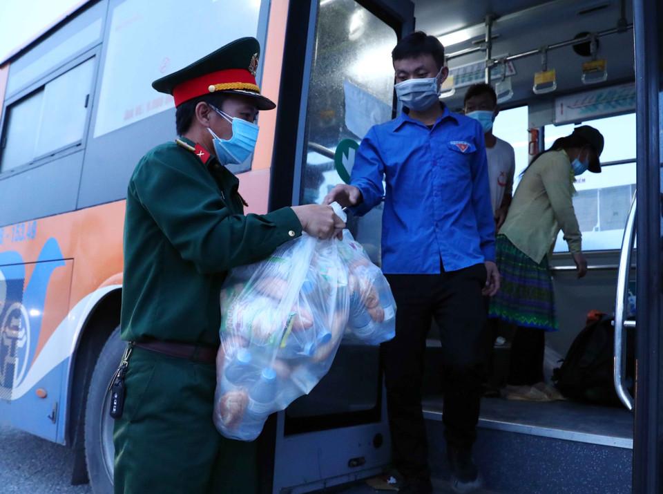 Lực lượng Quân đội tại chốt kiểm dịch số 1 QL 1A, huyện Phú Xuyên hỗ trợ đồ ăn cho người dân đi từ vùng dịch phía Nam về Hà Nội. (Ảnh: Phạm Kiên/TTXVN)