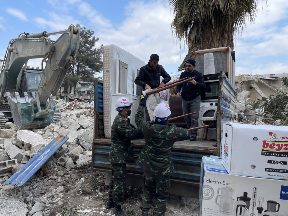 Các chiến sỹ lực lượng cứu hộ, cứu nạn của Quân đội Nhân dân Việt Nam giúp đỡ người dân di chuyển đồ khỏi nơi đổ nát. (Ảnh: TTXVN)