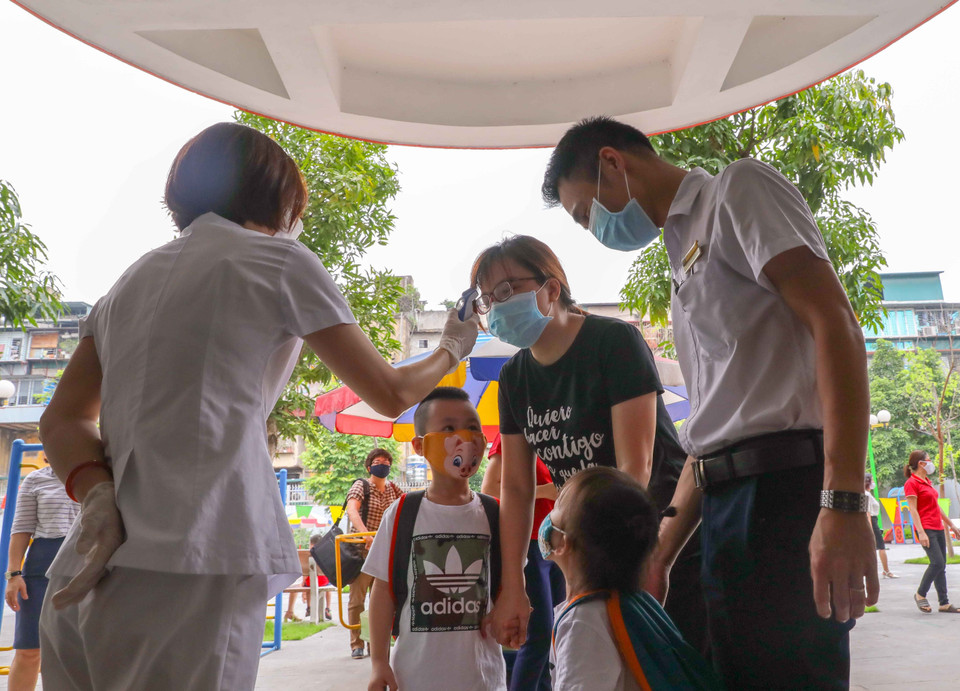 Ở khối mầm non, phụ huynh khi đưa, đón trẻ đều được kiểm tra thân nhiệt. (Ảnh: Thanh Tùng/TTXVN)