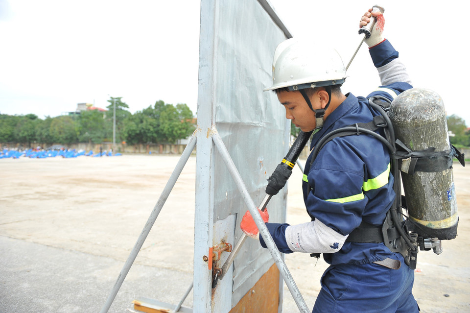 Chiến sỹ cảnh sát phòng cháy chữa cháy với bài tập phá khóa để chữa cháy đòi khỏi phải có sức khỏe và kỹ thuật. (Ảnh: Minh Đức/TTXVN)